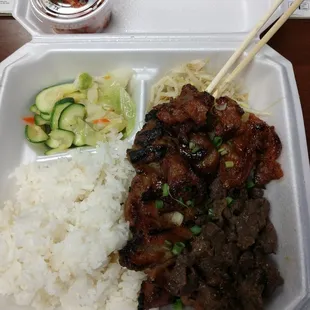 a take out container with rice, meat and vegetables