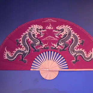 a red fan with dragon designs