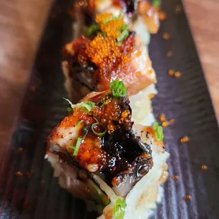sushi rolls on a black plate