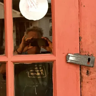 a man taking a picture through a window