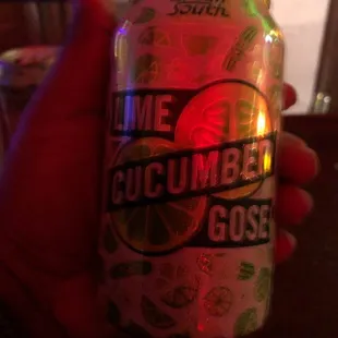 a person holding a can of lime cucumber gose