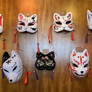 a variety of masks hanging on a wall