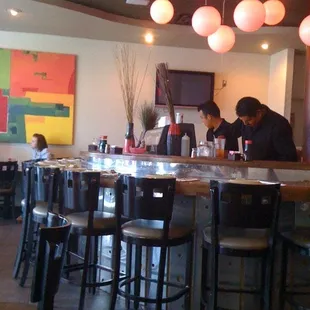 people sitting at the bar in a restaurant