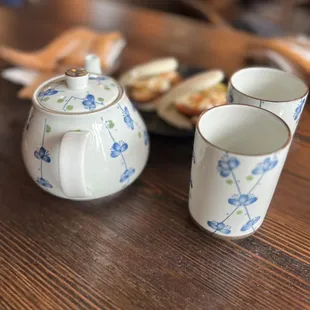 a teapot and two cups on a table