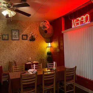 a dining room with a red neon sign