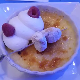 Creme brulee with mini beignets, whipped cream, and raspberries.