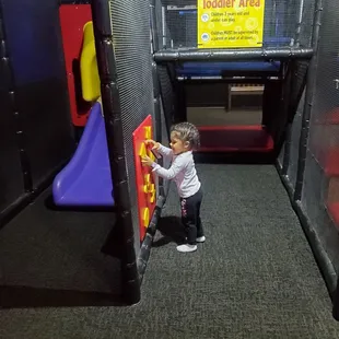 a toddler playing in a play area