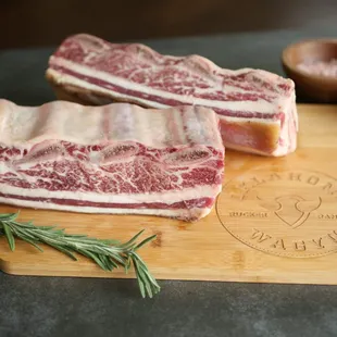 two pieces of meat on a cutting board