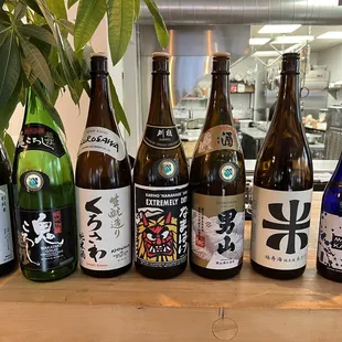 a variety of sake bottles on a table