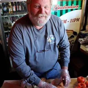 a man cutting tomatoes on a cutting board