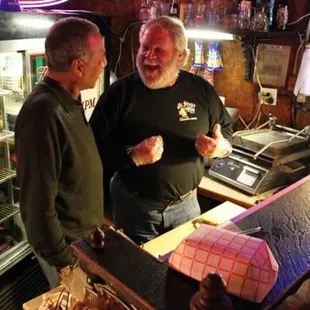 two men standing at a bar