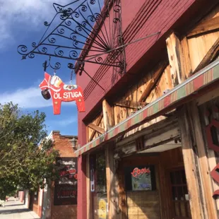 a storefront with a sign hanging from the side of the building