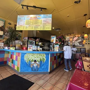 a man standing at the counter of a restaurant