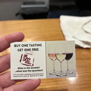 a hand holding a wine tasting card