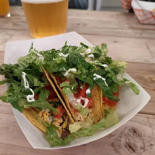 a plate of tacos and a glass of beer