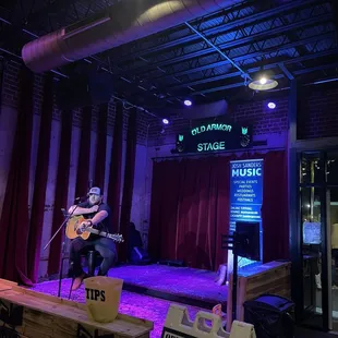 a man playing guitar on stage
