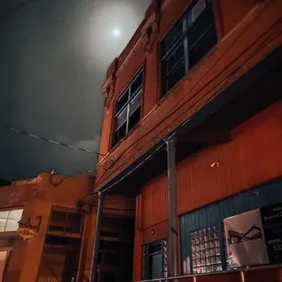 Darkened building with the moon right behind it