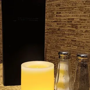 a candle, salt and pepper shakers