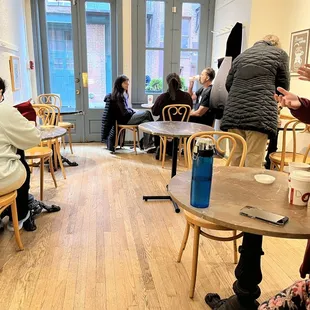 people sitting at tables in a cafe