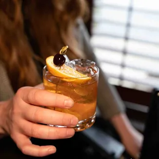 a woman holding a cocktail
