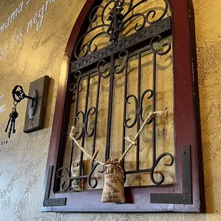 a window with iron bars and a vase of flowers