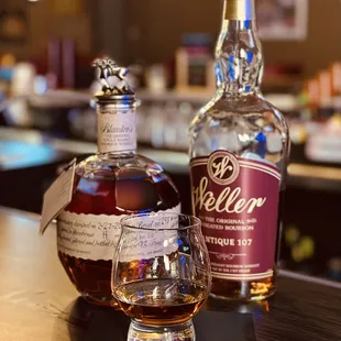 two bottles of wine and a glass