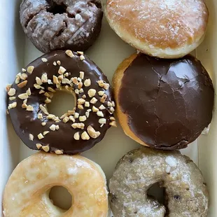 Chocolate cake, choco iced peanut, glazed, Bavarian cream, Boston cream and blueberry cake donuts.