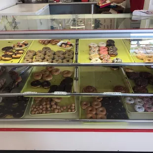 a variety of donuts in a display case