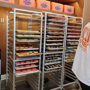 a man standing in front of a rack of donuts