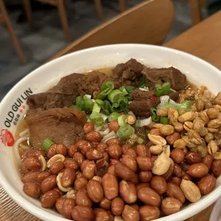 a bowl of noodles with meat and beans