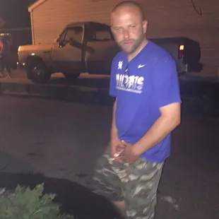 a man standing in a driveway at night