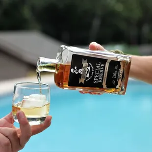 a person pouring a glass of whiskey