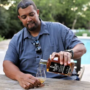 a man pouring a glass of whiskey