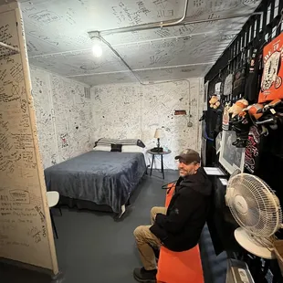 a man sitting in a room with a fan