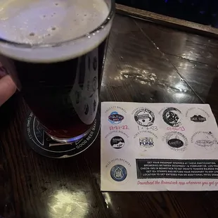 a hand holding a pint of beer
