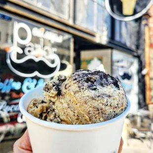 a hand holding a cup of ice cream