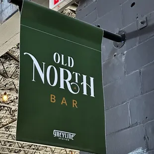 a green sign hanging from the side of a building