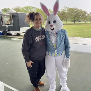 a woman standing next to an easter bunny