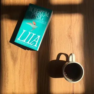 Book and coffee on the red oak bar.