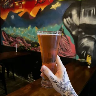 a hand holding a glass of beer