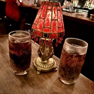 two glasses of soda and a lamp