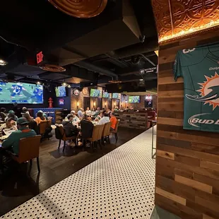 Dining area with a big screen and lot of nice TVs.