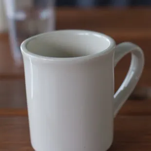 a white coffee cup on a wooden table