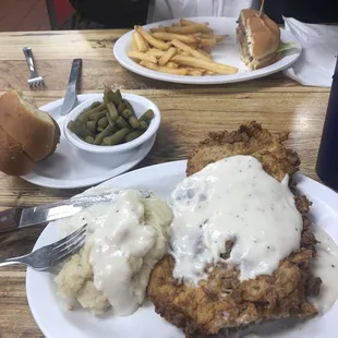 Chicken fried steak with mashed potatoes, green beans and home made dinner role.