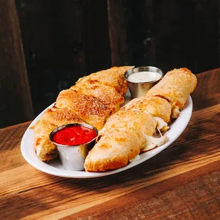 a plate of chicken roll ups with dipping sauce