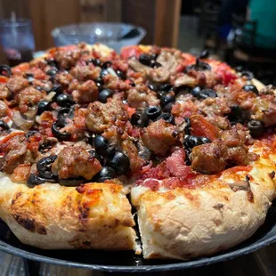 a pizza with meat and olives
