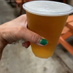 a hand holding a cup of beer