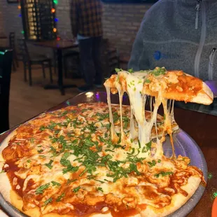 a woman holding a slice of pizza