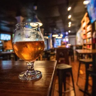 a glass of beer on a bar