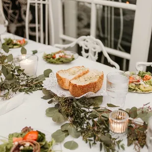 a table with bread, salads, and candles